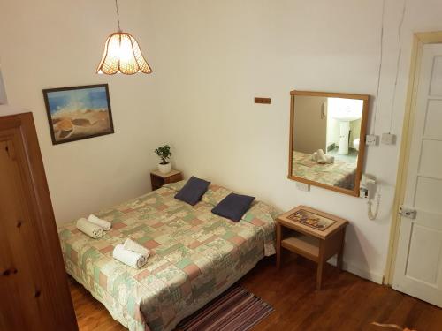 een kleine slaapkamer met een bed en een spiegel bij Trianon in Paphos City
