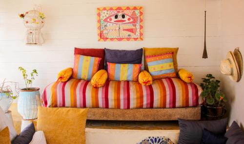a couch with colorful pillows in a room at Riad Lunetoile in Essaouira