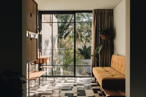 a living room with a couch and a large window at Casa Ixaya by Barrio México in Guadalajara
