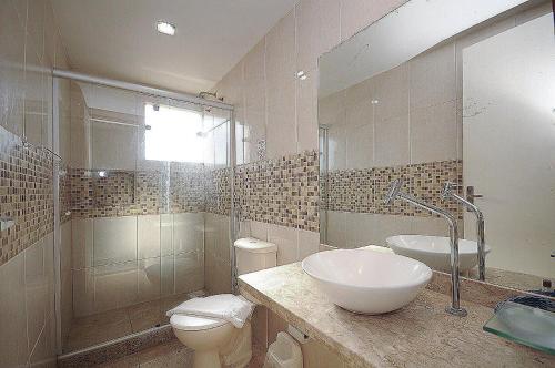 een badkamer met een wastafel, een toilet en een spiegel bij Pousada Brisas de Búzios in Búzios