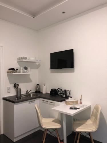 cocina con mesa y sillas y TV en la pared en Antwerp apartments, en Sarajevo