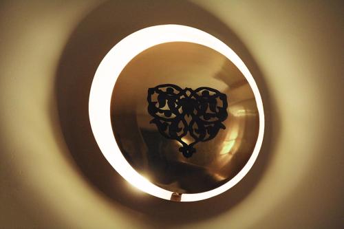 a round light with a black design on a wall at Hotel Artiç in Bursa