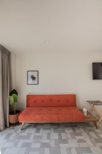 a living room with a red couch in front of a wall at Casa Ixaya by Barrio México in Guadalajara