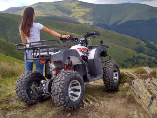 a woman standing next to a atv on a mountain at Гостьовий будинок in Izki