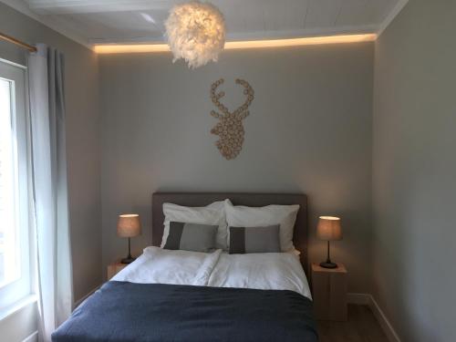 a bedroom with a bed and a chandelier at Ferienhaus am See in Wesenberg