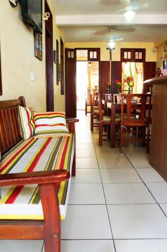 a restaurant with wooden benches and a table and chairs at Pousada Baobá e SPA in Olinda