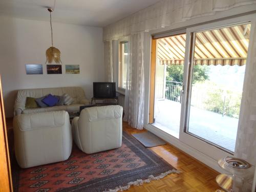 a living room with a couch and a large window at Casa Abel in Campione dʼItalia