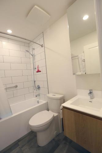 a bathroom with a toilet and a tub and a sink at Vancouver Traveller B&B in Vancouver
