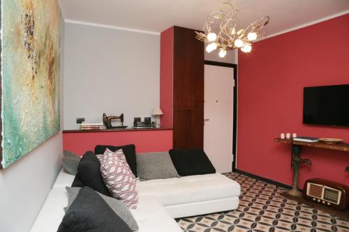 a living room with a white couch and a red wall at Jeans Luxury House in Genova