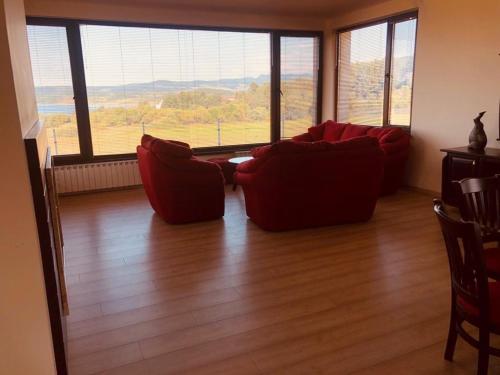 a living room with two red couches and a large window at VILLA RELAX in Tsigov Chark