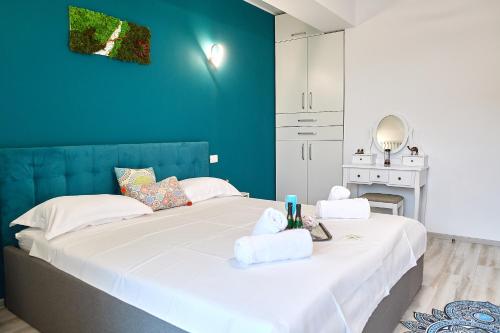 two beds in a room with a blue wall at Gota Place in Mamaia