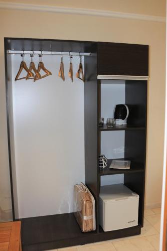a room with a closet with a shelf with wooden utensils at Eclat Suites Hotel Boutique in Villa Mercedes