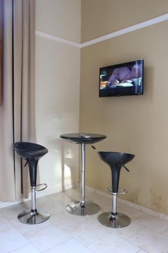 a table and two stools in a room with a tv at Eclat Suites Hotel Boutique in Villa Mercedes