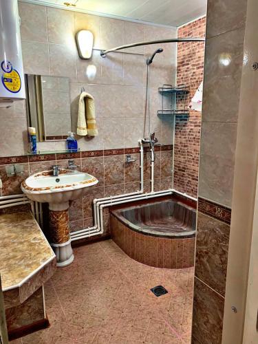 a bathroom with a sink and a bath tub at Hostel Imona in Samarkand