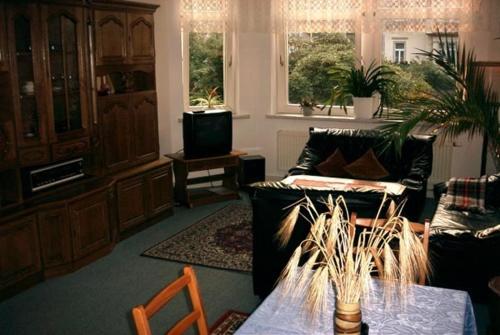 a living room with a couch and a table at Hotel-Pension Königswald in Dresden