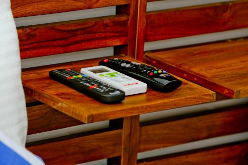 two remote controls and a video game controller on a shelf at Sapumal Lodge in Anuradhapura