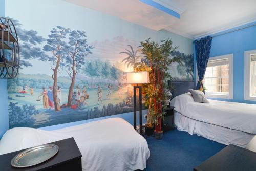 a bedroom with two beds and a painting on the wall at TOWNHOUSE 222 in New York