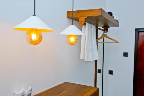 a table with three lights hanging from a wall at Sapumal Lodge in Anuradhapura