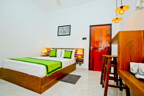 a bedroom with a bed and a desk in it at Sapumal Lodge in Anuradhapura