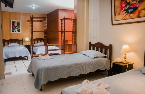 Habitación de hotel con 2 camas y espejo en Hotel Amoretto, en Trujillo