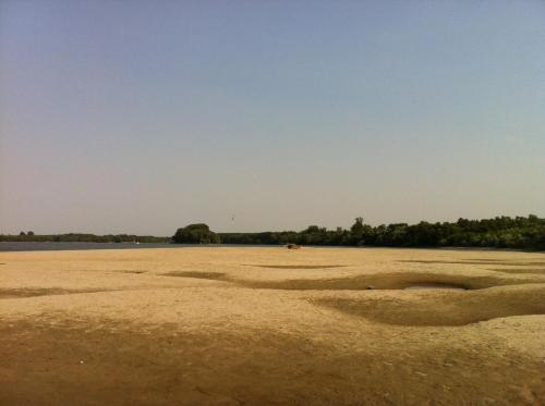 an empty beach with trees in the distance at kuća za odmor Vesna četiri zvjezdice in Opatovac