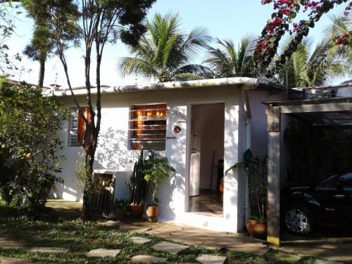 une maison blanche avec une voiture garée devant elle dans l'établissement Kitconforto, à Guarujá