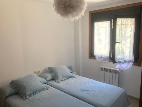 ein Schlafzimmer mit einem Bett und einem Kronleuchter in der Unterkunft Apartamentos Trebol in Sanxenxo