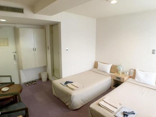 a hotel room with two beds and a table at Hotel Shibukawa Hills in Shibukawa