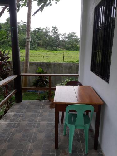 a wooden table and a green chair on a patio at Gardenview Homestay Siargao in General Luna