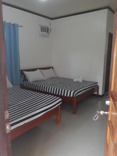 two beds sitting next to each other in a room at Gardenview Homestay Siargao in General Luna