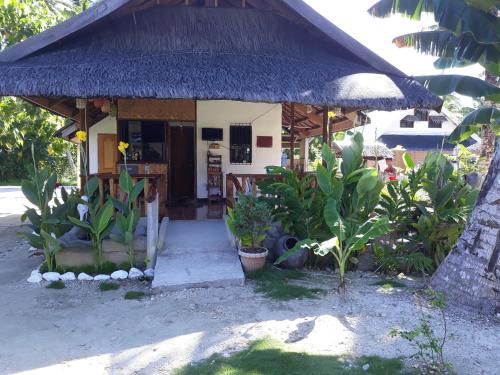 a small house with a straw roof at Gardenview Homestay Siargao in General Luna
