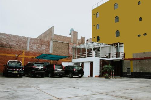 un grupo de autos estacionados en un estacionamiento al lado de un edificio en Hotel Amoretto, en Trujillo