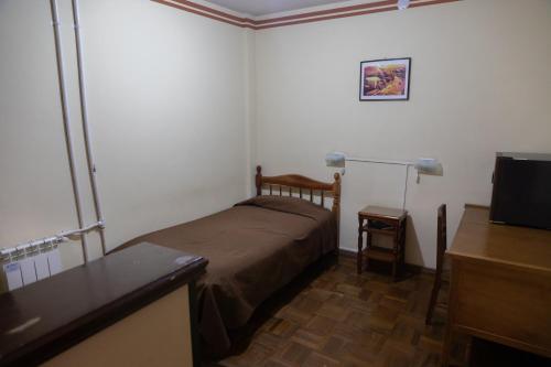 a small bedroom with a bed and a flat screen tv at Julia Plaza Hotel in Uyuni