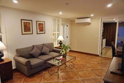 a living room with a couch and a table at Viangbua Mansion in Chiang Mai