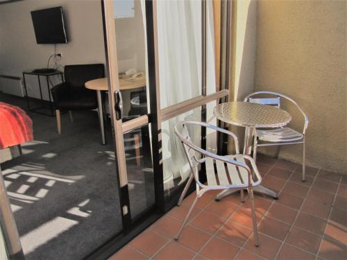 a room with a table and a table and chairs at The Beachcomber Hotel in Nelson