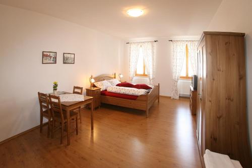 a bedroom with a bed and a table and a dining room at Penzion U Chodskeho Hradu in Domažlice