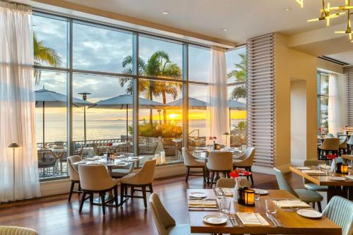 un restaurante con mesas y sillas y vistas al océano en Hyatt Regency Trinidad en Puerto España