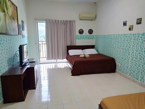 1 dormitorio con 1 cama y TV en Homestay Pagar Buruk Bukit Merah L4 - AIR CONDITIONED, en Kampong Selemat