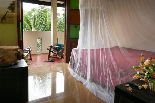 a bedroom with a bed with a mosquito net at Dream House in Hikkaduwa