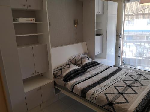 - une petite chambre avec un lit et une fenêtre dans l'établissement Agréable Studio Lumineux, à Aix-les-Bains