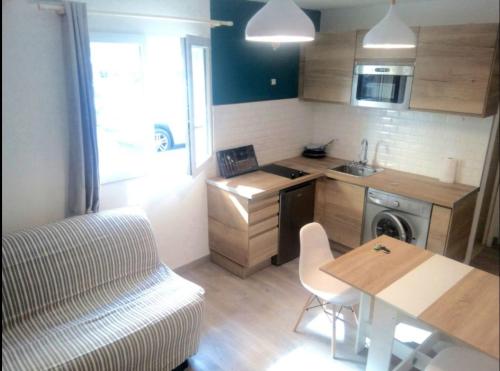 - une petite cuisine avec une table et un canapé dans l'établissement Charmant studio climatisé à 300m du port. Refait à neuf., à Bastia