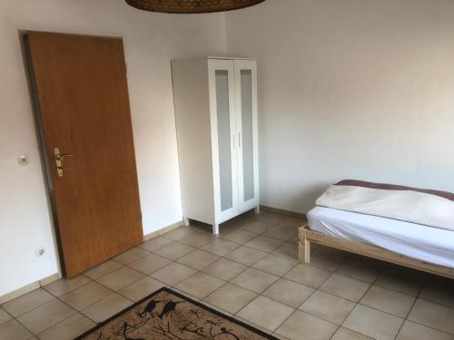1 dormitorio con 1 cama y puerta de madera en Wohnung 3, en Alzenau