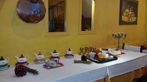 a table with a white table cloth with tea sets on it at Hôtel Saint Vincent in Bagnères-de-Bigorre