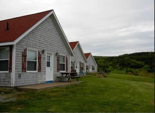 a group of houses with a picnic table in a yard at Chisholms of Troy Coastal Cottages in Port Hawkesbury