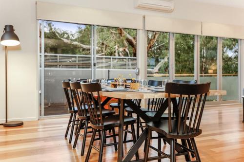a dining room with a wooden table and chairs at Seascape - The Ultimate Inverloch Retreat in Inverloch