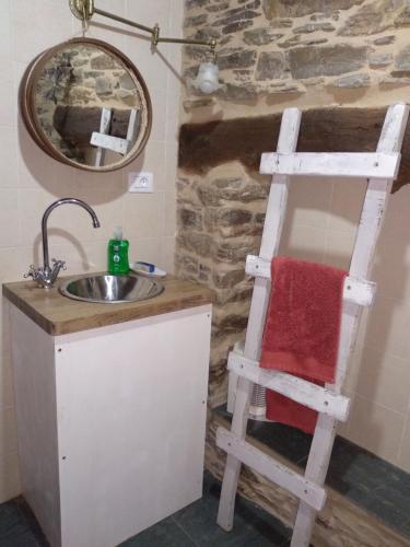 ein Badezimmer mit einem Waschbecken, einem Spiegel und einer Leiter in der Unterkunft Casa Paulo in Luaces