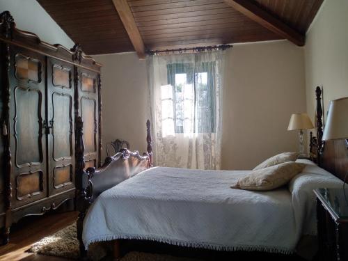 a bedroom with a large bed and a window at Casa Paulo in Luaces