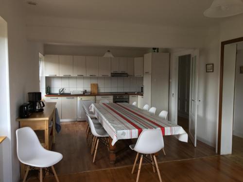 a kitchen with a large table and white chairs at gîtes au domaine Greiner in Mittelwihr