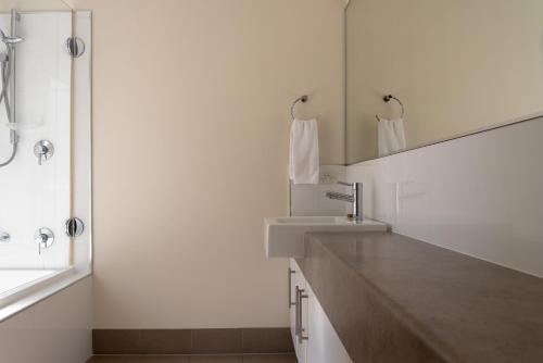 a bathroom with a sink and a mirror and a shower at Cape Villas Dunsborough Unit 2 in Dunsborough
