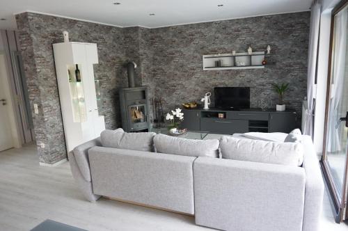a living room with a white couch and a brick wall at Moderne Erdgeschoss Kleikamp 4a in Königslutter am Elm
